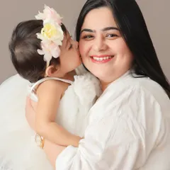 There's nothing sweeter than a kiss from your little one. This portrait captures that pure, unfiltered love between a mother and her daughter, a perfect moment frozen in time.