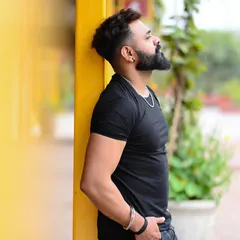 An outdoor portrait of a male model against a vibrant yellow wall. The contrast and composition create a strong, eye-catching image for a fitness or street style portfolio.