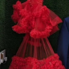 A red ruffle baby frock with a detachable tail. This is a fun and dramatic outfit for a little one's birthday or special photoshoot.