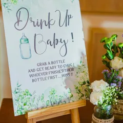 Get ready to 'Drink Up Baby!'. This fun game challenges guests to a bottle-chugging contest. I create these custom signs and set up the station to add another layer of entertainment to your baby shower.