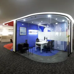 For Scientific Games, we designed this semi-private meeting pod using curved glass walls and a bold blue color scheme. It provides a quiet space for focused discussion while maintaining a visual connection to the open and energetic office environment.
