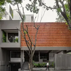 This is our own studio, Akshara Vinyasaa, where our design philosophy comes to life. The facade features a screen of locally sourced terracotta bricks, a climate-responsive element that provides natural cooling while creating a visual connection to the earth.