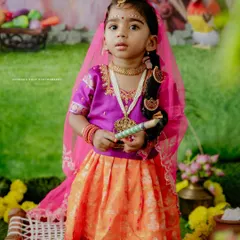 A full-length portrait of the little girl in her Janmashtami attire. The detailed costume and traditional props create an authentic and beautiful festive photograph.