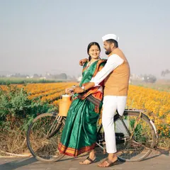 Capturing the joy of the journey together. This shot, with the couple on a classic bicycle against the backdrop of a marigold farm, has a timeless, rustic feel that is perfect for telling a traditional love story.