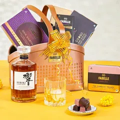 A luxurious Diwali hamper featuring Japanese whiskey paired with artisanal chocolates. The clean, elegant styling against a bright yellow background creates a modern and sophisticated festive look.