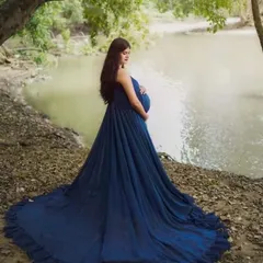 We can create stunning, dramatic portraits outdoors. This shot was taken by a serene riverside in Karnataka, with the long trail of the blue maternity gown adding a touch of magic to the natural landscape.