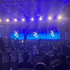 The view from the side of a massive stage for UST's 25th-anniversary celebration. Performing for thousands of employees requires a show that is big, visual, and energetic enough to fill a venue of this scale.