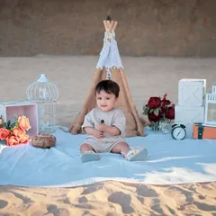A full view of our boho-chic beach picnic setup, complete with a teepee, lanterns, and flowers, creating a beautiful scene on the sand.