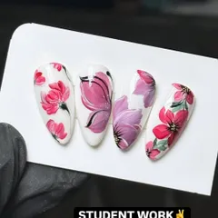 This is the level of detail and artistry my students achieve. This example of student work shows intricate, hand-painted floral designs on almond-shaped nail tips, demonstrating the high-quality techniques taught in my nail art design workshops.