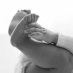 Those tiny feet they love to grab! This detailed black and white shot focuses on the adorable milestone of discovering their own toes. It’s these little moments that make the six month session so special.