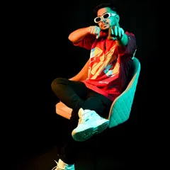 A shot from a recent photoshoot, playing with colored lighting. The glow and the pose reflect the vibrant, dynamic energy of my tracks.
