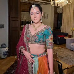 The sister of the bride in a stunning multi-colored lehenga. The makeup is vibrant and fresh, with a focus on glowing skin and a defined eye that complements the colorful outfit perfectly.