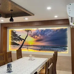 This backlit scenic mural of a beach sunset transforms the entire dining area. The integrated lighting enhances the colors of the sky and creates a warm, inviting glow.