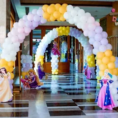 A closer look at the entrance arch for the princess-themed welcome party. I used pastel yellow, purple, and white balloons and placed cutouts of Princess Jasmine, Rapunzel, and Aurora to greet the guests.