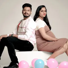 A playful studio shot for a gender reveal. We use simple props like pink and blue balloons to add a fun, conceptual element to your couple's maternity photoshoot.