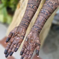 This stunning full-arm bridal mehendi showcases a variety of traditional patterns, including elephants, floral bands, and intricate jaali (net) work.