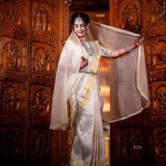 The bride playfully shows off her sheer veil, which complements the elegant Kannadiga-style drape. This fusion look was perfect for her reception, combining grace with a touch of modern flair.