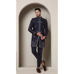 The Neel Amber achkan in a deep, opulent navy. This handcrafted piece features intricate geometric patterns and mirrored embellishments for a look of timeless luxury.