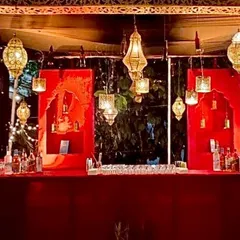 For a royal, sangeet-style theme, we designed this rich red bar setup. The look was completed with intricate golden latticework and hanging Moroccan lanterns to create a warm and opulent atmosphere.