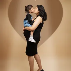 Love, framed by love. The heart-shaped shadow was a creative touch to symbolize the growing love in this family. A mother's kiss for her daughter is a timeless expression of their beautiful bond.