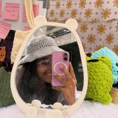 A mirror selfie of me wearing one of my handmade crochet bucket hats. This grey hat is lightweight and breathable, making it a perfect accessory for a sunny day out.
