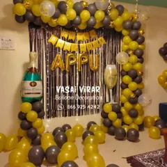It's party time. This fun and stylish setup for an adult birthday features a black and yellow balloon arch against a silver fringe curtain, complete with champagne bottle and glass foil balloons to set the mood.