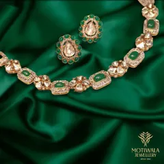 A beautiful necklace and earring set featuring Polki diamonds set with vibrant green enamel. The design is classic and elegant, perfect for festive occasions.