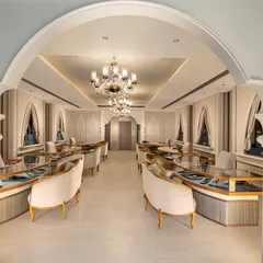 I designed this luxury jewellery showroom to be a masterpiece of classic elegance. The interior view showcases bespoke curved seating, grand chandeliers, and arched entryways that frame the space, creating an exclusive and sophisticated environment for a high-end retail experience.