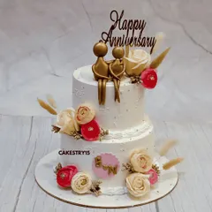 A romantic two-tier chocolate anniversary cake. This 3kg cake is adorned with fresh roses and features a golden silhouette topper of a couple, celebrating their love story.