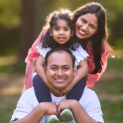 A perfect family portrait filled with smiles. I love the classic "child on shoulders" pose, which creates a beautiful, layered composition and showcases the happy connection between parents and their child.