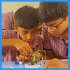 Two students concentrate on assembling their project, carefully connecting wires to a breadboard. This is where theoretical knowledge becomes a tangible result, building both skills and confidence.