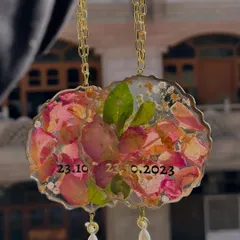 A pair of custom car hangings made from preserved flower petals, personalized with a special date.