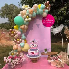 A close-up of the birthday cake and decor, showcasing the personalized details like the flower-shaped balloons and custom signage.