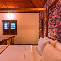 This view showcases the room's beautiful wooden ceiling and slatted window, which add to the rustic charm. The design prioritizes natural materials and traditional craftsmanship to create a serene guest experience.