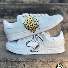 A unique design for a client who wanted to represent his spirit animal and beliefs. We painted a golden Karma symbol on one Adidas shoe and a white wolf on the other, both accented with paint splatters.