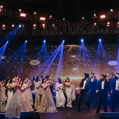 A classic 'ladkivale vs ladkevale' moment. The stage is set for a friendly dance battle, a highlight of any sangeet that we love to choreograph.