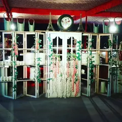 A rustic, shabby-chic counter setup we designed for a themed event. The white paneled wood, decorative vines, and vintage-style props create a charming and unique food station.
