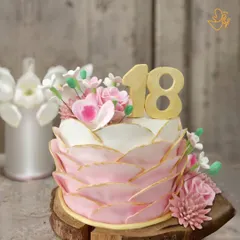 An elegant floral cake for an 18th birthday. The design features soft pink petals with gold edging and beautiful sugar flowers, marking the special milestone in style.