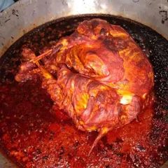 A whole roasted chicken or lamb leg simmering in a deep red, spicy gravy. This is a showstopper dish for a special occasion.