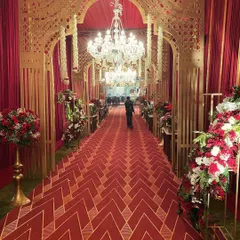 For those who dream of timeless grandeur, I craft entrances that speak the language of royalty. This opulent passageway for a royal Indian wedding features intricate gold-lacquered arches, magnificent chandeliers, and a rich red carpet, setting a majestic tone from the very first moment.