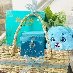 A close-up of the branded hamper for Ivana, featuring their custom card, a cute plushie, and products that match their brand's turquoise color scheme.