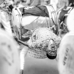 The black and white version of the acrobatic dhol player, emphasizing the raw power and motion of the performance.