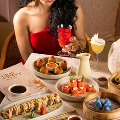 A stylish woman enjoying a meal and a cocktail. This creates an aspirational vibe, associating the restaurant with elegance and fun.