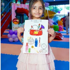 A proud young artist shows off her coloring of a makeup kit, a perfect activity for our pamper-themed parties.