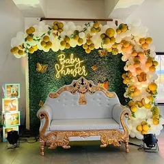 The full baby shower setup, including an ornate white and gold throne for the mom-to-be, making her feel extra special.