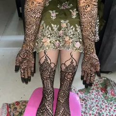 A complete bridal look for Tuba, with matching intricate designs on both her arms and legs. The patterns are dense with floral and traditional motifs.