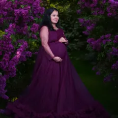 A fairytale moment for a mother-to-be. This outdoor portrait showcases one of the elegant maternity gowns I provide, set against a stunning backdrop of purple flowers to create a vibrant and dreamy image.
