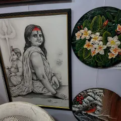 A display of my varied works, including a detailed charcoal portrait of a woman with Ganesha, and two circular floral paintings.