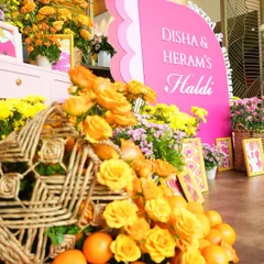 A burst of color for the Haldi ceremony, with vibrant yellow and orange flowers, fresh fruits, and a playful pink sign. Every detail was designed to feel fresh, bright, and full of love.