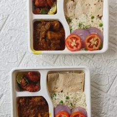 Here are two of our popular non-veg thalis packed and ready for a corporate delivery. Each thali features our Bengali Chicken Curry, spicy Chicken 65, Peas Pulao, Chapati, and a fresh salad.